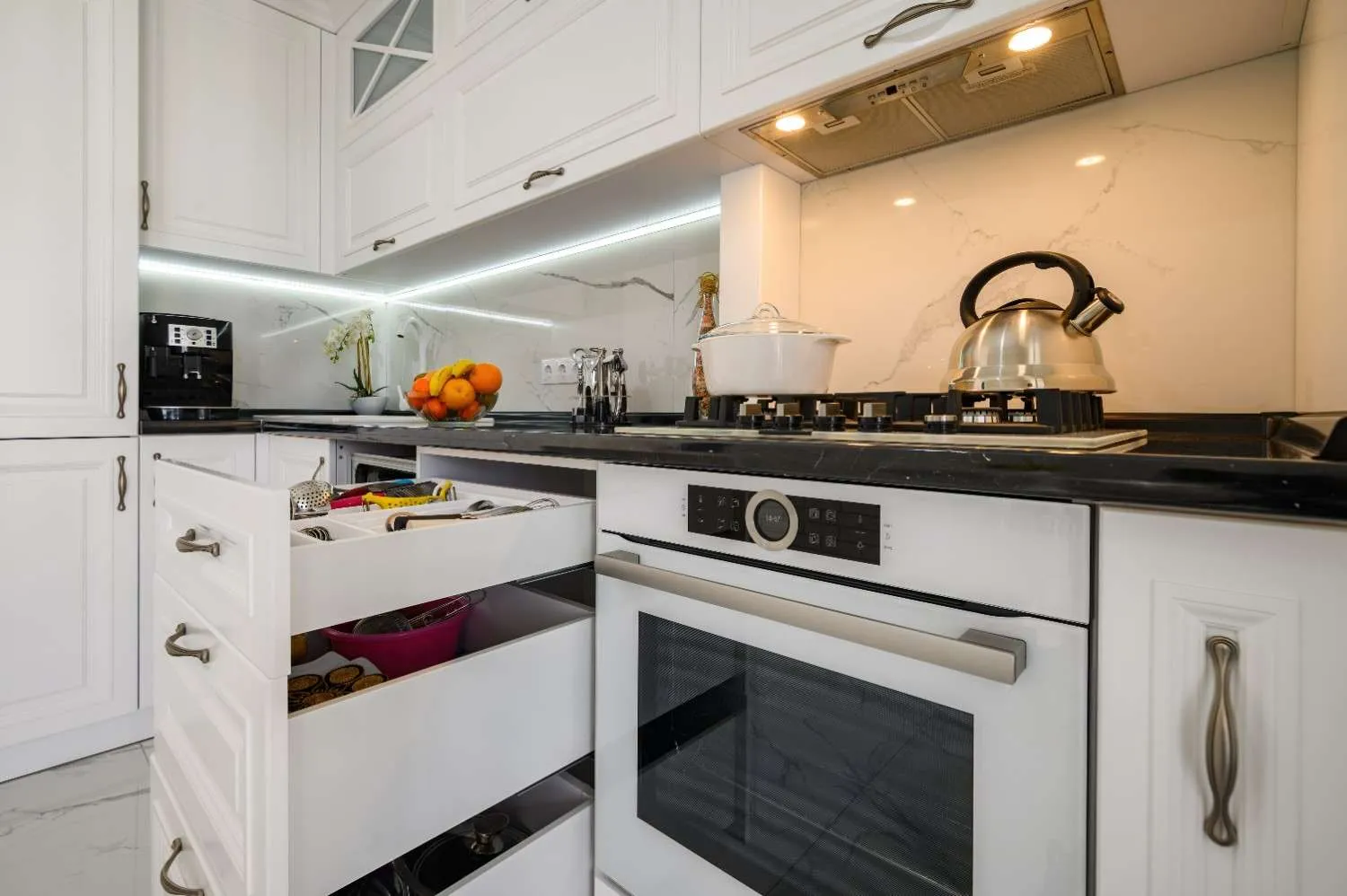 Kitchen with white cabinets, a built in oven and a gas cooktop
